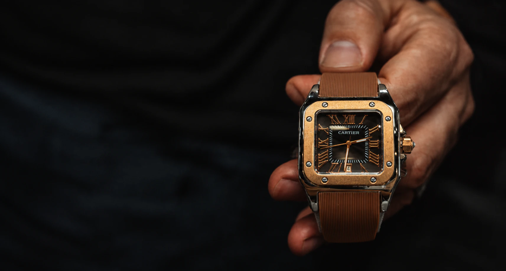 Reloj con correa marrón en la mano